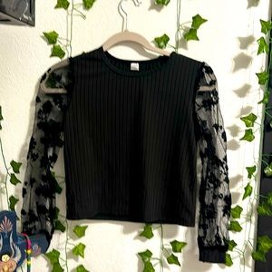 It has see through sleeves with black flowers and a very soft material.